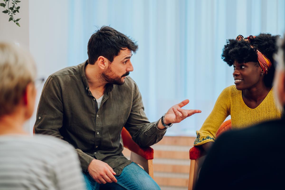 Man en vrouw in gesprek in groepsverband