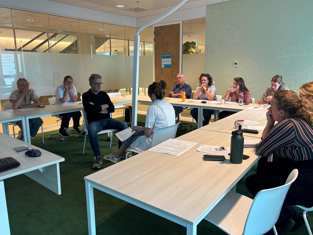 Zorgprofessionals zitten in een klaslokaal en volgen een masterclass proactieve zorgplanning